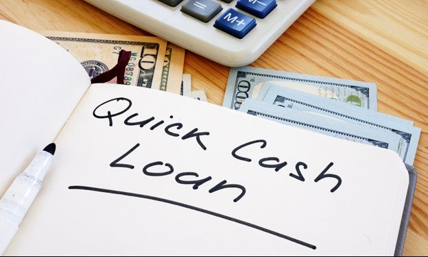 Notes and ‘’writing quick cash loan’’ with money on the desk